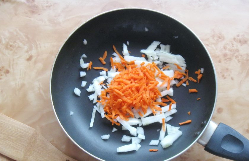 1. Этап. Ленивые вареники с капустой: Морковь и репчатый лук очистите, помойте. Лук нарежьте мелким кубиком, а морковь натрите на терке. Выложите в сковороду.