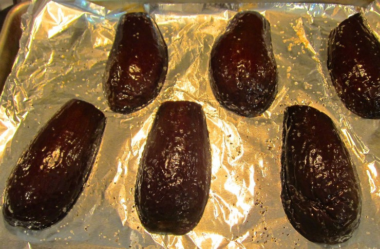 1. Этап. Баклажаны, фаршированные фаршем, в духовке: Первым делом мы разрезаем каждый баклажан пополам и выкладываем половинки (срезом вниз) на противень, застланный фольгой. Сбрызгиваем баклажаны оливковым маслом, посыпаем солью и перцем, ставим на 20 минут в разогретую до 220 градусов духовку.