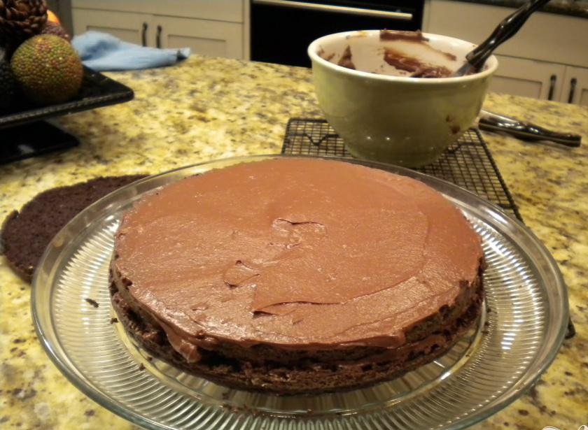 1. Этап. Шоколадный торт Черная вуаль: 4. Разрежьте коржи горизонтально на две части. Один корж подробите и отставьте. Другой корж расположите на подносе, и обмажьте слоем крема. Накройте коржом. Смажьте кремом и накройте оставшимся коржом. Оставшимся кремом смажьте бока торта и верхнюю часть торта и посыпьте раскрошенным коржом.