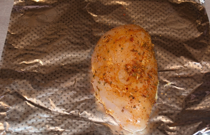 1. Этап. Куриная грудка под соусом: Чтоб сэкономить на мытье посуды, возьмите фольгу, сложенную вдвое. Уложите на нее куриное филе.