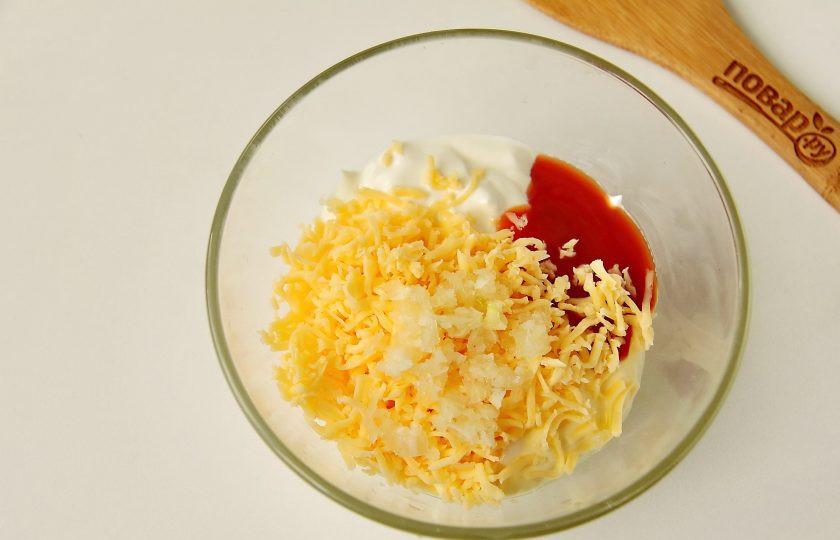 1. Этап. Сельдь в сырном соусе: Соедините сметану, майонез, томатный соус, тертый на мелкой терке сыр и пропущенный через пресс чеснок.