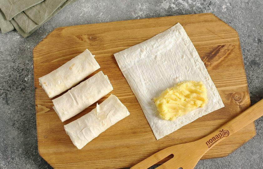 1. Этап. Трубочки из лаваша с картофельной начинкой: Смажьте каждый кусочек лаваша сметаной и ближе к одному краю выложите начинку. Подверните края с двух сторон, и сверните лаваш трубочкой.