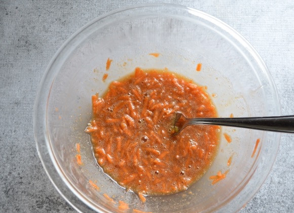 1. Этап. Пирог из моркови и ржаной муки: 2. Морковь очистите и натрите на крупной терке, переложите ее в миску и добавьте желток, растительное масло, сахар, ванильный экстракт.