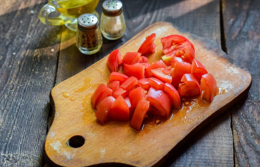 1. Этап. Хрустящие баклажаны с помидорами и кинзой: Помидоры сполосните и просушите, нарежьте небольшими кубиками.