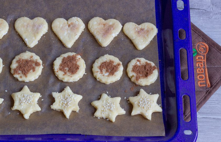 1. Этап. Творожное печенье с корицей и кунжутом: Выложите заготовки на противень, застеленный пекарской бумагой и посыпьте кунжутом, корицей, корицей с сахаром или просто сахаром. Поставьте печенье в разогретую до 180 градусов духовку на 15-30 минут до румяности. Время выпечки зависит от размера и толщины печенья.