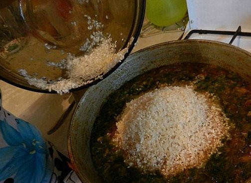 1. Этап. Плов бухарский: Добавить зелень, посолить, поперчить. Готовить еще полчаса на медленном огне под крышкой, при необходимости подливая воду. Выложить рис.