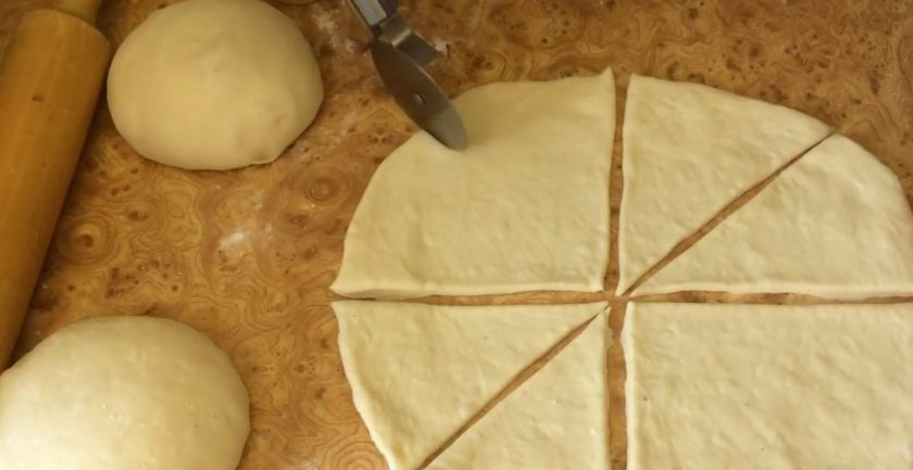 1. Этап. Рогалики с шоколадной начинкой: Накройте тесто миской и оставьте на 15 минут. Разделите тесто на три части, каждую скатайте в шар и раскатайте в тонкую лепешку. Разрежьте тесто на 8 одинаковых прямоугольников.