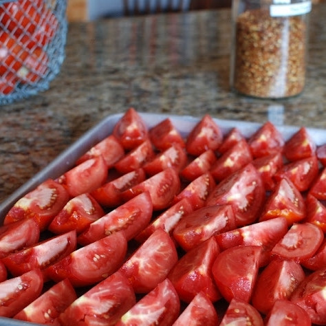 1. Этап. Помидоры, сушеные в духовке: Выкладываем четвертинки помидоров на противень, слегка смазанный оливковым маслом.