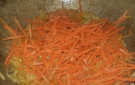 1. Этап. Салат из патиссонов: 2. Тем временем очистите и натрите на такой же терке морковь, добавьте ее в казан, перемешайте и обжаривайте до мягкости моркови.