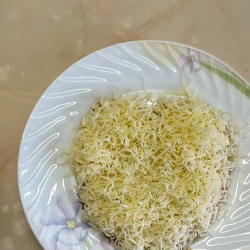 1. Этап. Салат Клубничка: Сыр натереть на мелкой терке и выложить на слой из мяса.