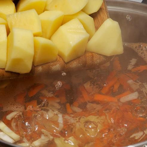 1. Этап. Русский постный суп: Почистите и порежьте крупно картофель и добавьте в кастрюлю.