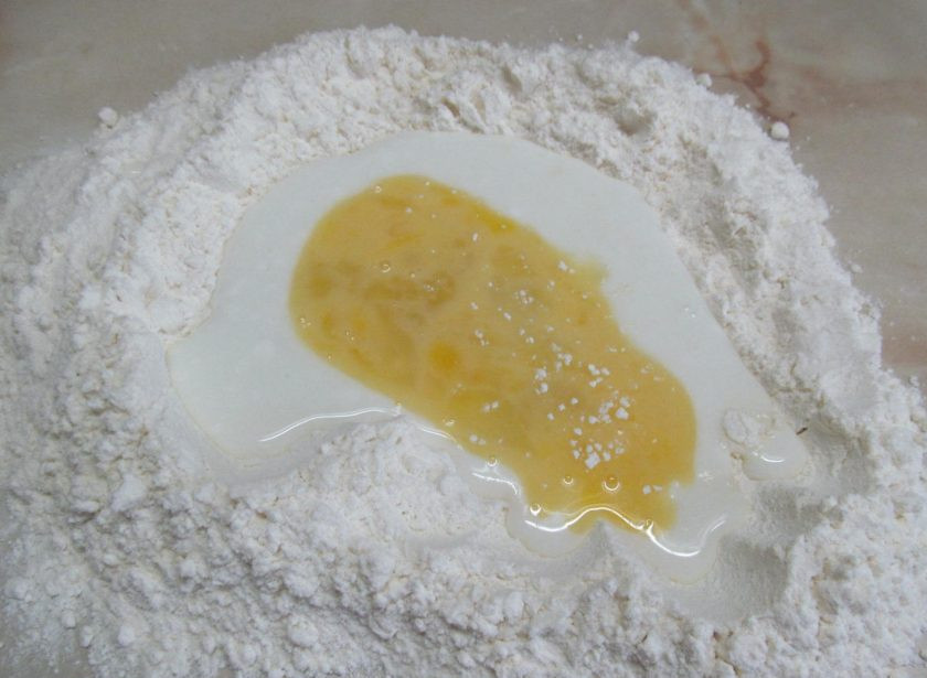 1. Этап. Лепешки на простокваше с творогом и зеленью: Сначала приготовим тесто. На стол высыпать пару стаканов муки, в центре сделать воронку и влить простоквашу и взбитое яйцо. Добавить щепотку соли и соду. Замешиваем тесто, подсыпая оставшуюся муку (сколько пойдет). Замешиваем, пока тесто перестанет липнуть к рукам.