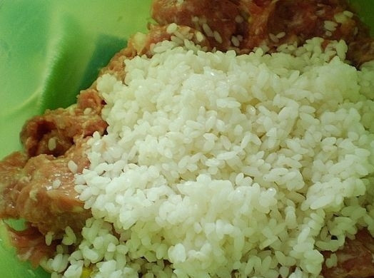 1. Этап. Тефтели, запеченные в духовке в сметанном соусе: 4. Выложите в фарш рис. Посолите и поперчите по вкусу.