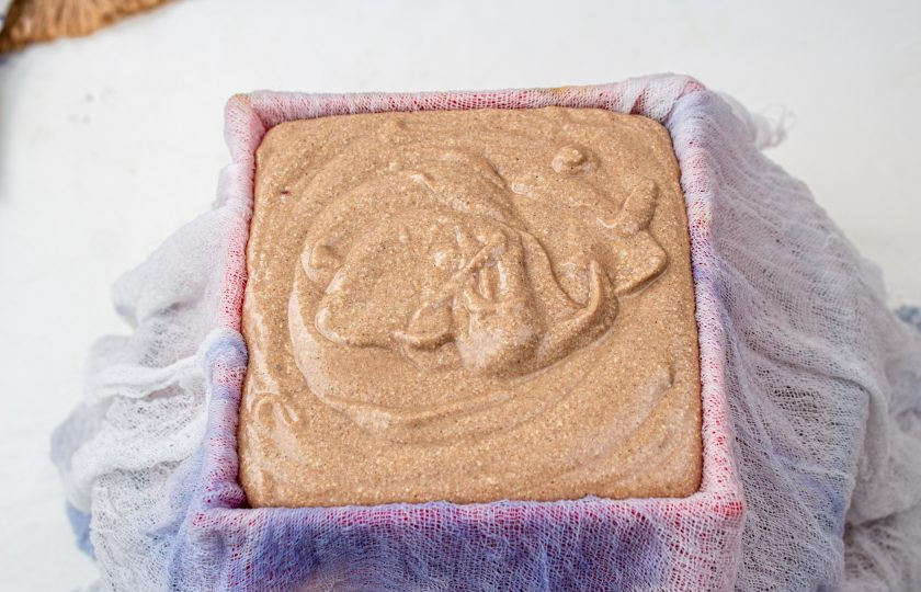 1. Этап. Творожно-шоколадная пасха заварная: Марлю намочите в холодной воде и выстелите в пасочницу в 2 слоя, чтобы свисали края. Вылейте творожную массу.