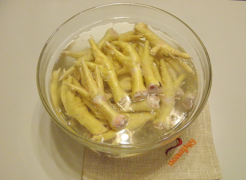 1. Этап. Студень из курицы: Сложите лапки в глубокую миску, залейте их кипятком, оставьте на 10 минут распарится. Делается это для того, чтобы потом было легче снять с них кожу.