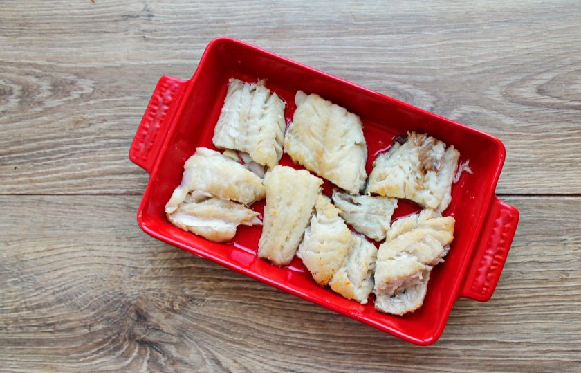 1. Этап. Судак в сырном суфле: Филе судака сполосните, обсушите и порежьте на кусочки. В сковороду налейте растительное масло и обжарьте рыбу с двух сторон по 1 минуте и переложите в форму для запекания.