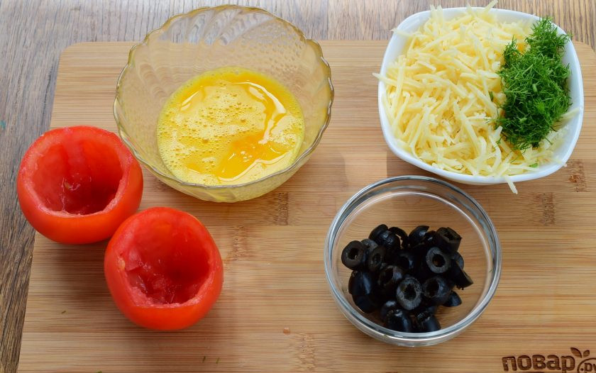 1. Этап. Фаршированные томаты: Срежьте верхушку помидоров, с помощью чайной ложки достаньте мякоть. Яйцо слегка взбейте. Маслины нарежьте колечками. Сыр натрите на мелкой терке, зелень измельчите, перемешайте.