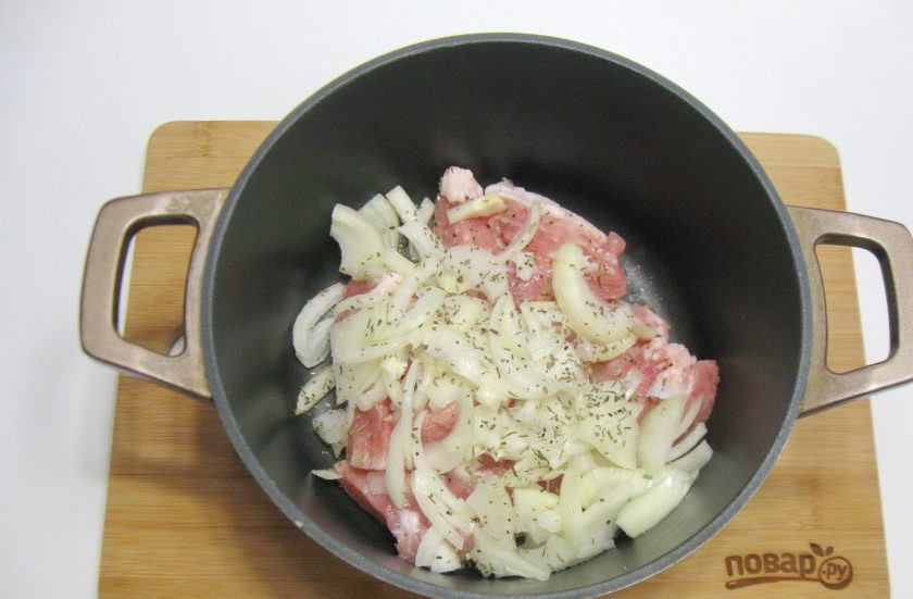 1. Этап. Басма в казане: В казан или кастрюлю с толстым дном выложите мясо и лук. Посыпьте немного солью и базиликом.