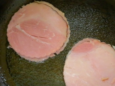 1. Этап. Завтрак Бенедикт: На разогретой и смазанной маслом сковороде обжариваем с обеих сторон ломтики ветчины.