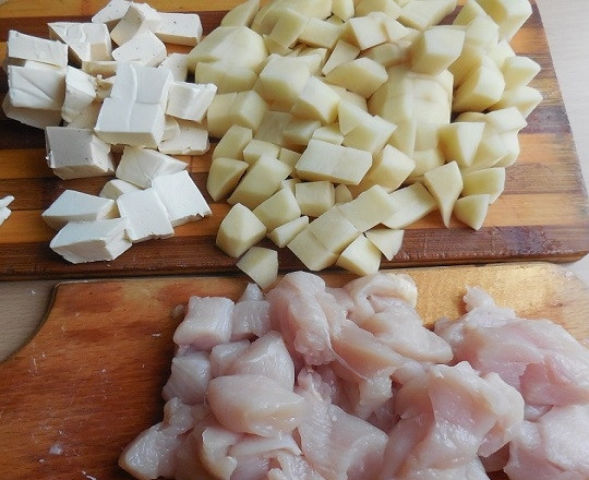 1. Этап. Грибной суп из шампиньонов с плавленым сыром: 3. Пока обжаривается лук, очистите и нарежьте небольшими кубиками картофель и сырки. Вымойте и нарежьте куриное филе, если будете его добавлять.