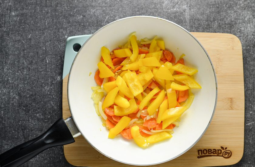 1. Этап. Соте из баклажанов: Добавьте в сковороду нарезанный на крупные кусочки болгарский перец. Перемешайте, обжаривайте пару минут.