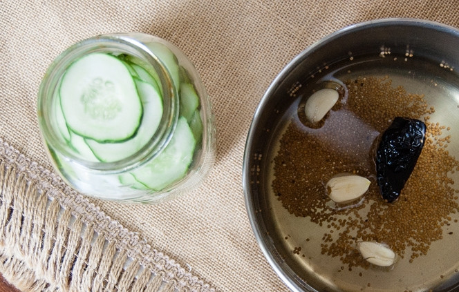 1. Этап. Кисло-сладкие огурчики на зиму: В кастрюле доведите до кипения воду с уксусом, сахаром и солью, дайте прокипеть пару минут, помешивая, пока сахар не растворится. Затем добавьте чеснок и зерна горчицы в маринад.