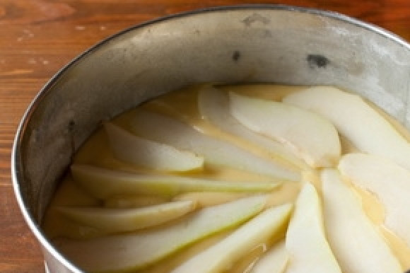 1. Этап. Шарлотка с грушей: Выливаем в форму часть теста, выкладываем груши. Посыпаем их лимонной цедрой, сбрызгиваем лимонным соком и заливаем оставшимся тестом.