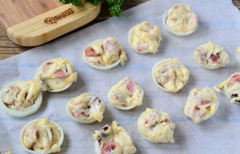 1. Этап. Хот-дог в луковых колечках: Ложкой выложите вкуснейшую начинку в каждое колечко. Оставьте кольца с начинкой или при комнатной температуре на 30 минут, или на 10 минут отправьте в холодильник.