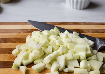 1. Этап. Торт Моцарт: 4. Очистите яблоки и порежьте на небольшие кубики. Пожарьте на разогретой сковороде на сливочном масле сахарную пудру и яблоки с корицей. Яблоки не должны разваливаться. Налейте ром и подожгите. Переложите продукты на тарелку.