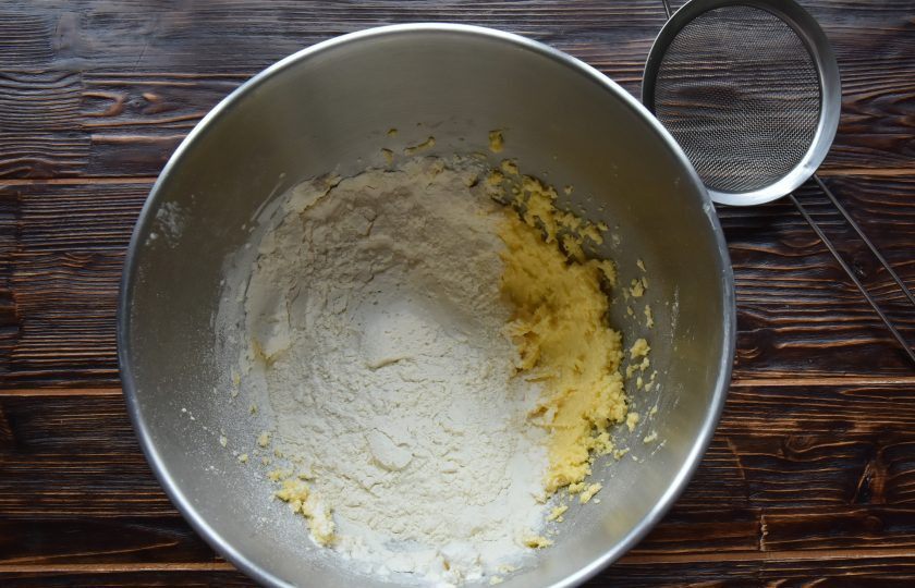 1. Этап. Пирог Ложный сырник: Муку соедините с разрыхлителем и просейте через сито. Добавьте к масляно-яичной смеси и перемешайте лопаткой.