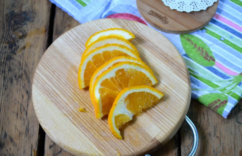 1. Этап. Компот из крыжовника с апельсином на зиму: Апельсин порежьте на дольки. Обратите внимание: можно использовать только мякоть апельсина, а можно брать и цедру. Я не очищаю апельсин, его цедра придает компоту насыщенный вкус.