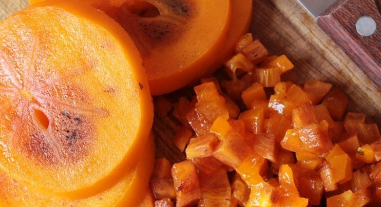 1. Этап. Интересный салат на день рождения: Вымойте хурму, обсушите и очистите ее от кожицы, достаньте из нее косточки. Мякоть хурмы нарежьте на кубики. Очень важно, чтобы хурма была сладкой и не терпкой.