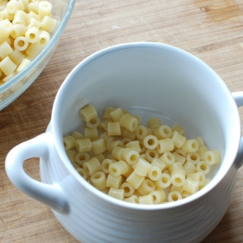 1. Этап. Густой итальянский томатный суп с макаронами и фаршем: Готовый суп снимаем с огня. В порционную тарелку кладем немного готовых макарон.