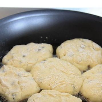 1. Этап. Вкусные сырники: Выложить сырники в сковороду с небольшим количеством масла. Обжарить примерно 3-4 минуты с одной стороны.