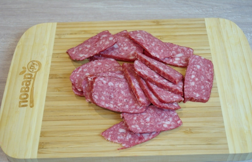 1. Этап. Мясная нарезка в виде ёлочки: Другие колбасы нарезаем таким же образом. Важно нарезать довольно тонко, равными кусочками. Если у вас дома есть слайсер, процесс пойдет быстрее и эффективнее. Еще можно купить колбасные изделия в крупном супермаркете и прямо там нарезать всё на слайсере.