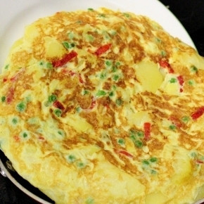 1. Этап. Испанская тортилья: 8. Добавьте в сковороду еще ложку масла и выложите тортилью в сковороду. Обжарим тортилью с другой стороны. Накройте крышкой и жарьте еще минуту-две.