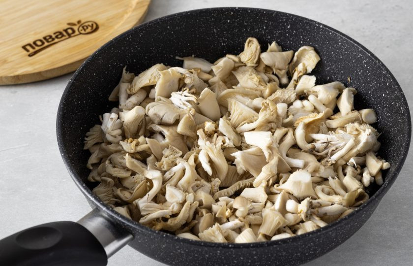 1. Этап. Вареники с вешенками: Добавьте порезанные вешенки. Жарьте на огне чуть выше среднего около 10 минут, чтобы грибы подрумянились. Посолите и поперчите по вкусу в конце.