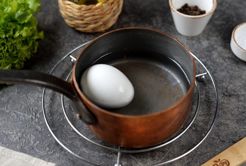 1. Этап. Салат с морепродуктами и красной икрой: Отварите крупное куриное яйцо не дольше 10 минут, остудите в холодной воде.