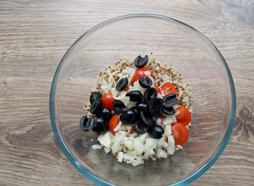 1. Этап. Салат с киноа и курицей: Маслины обсушите от жидкости и разрежьте пополам. Добавьте их в салат.