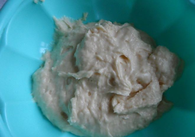 1. Этап. Творожная Лакомка на песочном тесте: Добавьте к маслу яйцо и 120 грамм сахара. Перемешайте, просейте муку с разрыхлителем и замесите тесто. Поместите его на 1 час в холодильник.