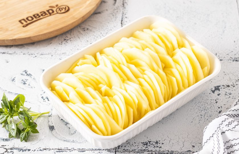 1. Этап. Гратен на кокосовом молоке: В форму для выпечки выложите картофель слоями, как на фото. Дно формы предварительно смажьте растительным маслом.