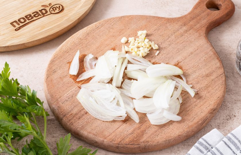 1. Этап. Тушеная тыква с морковью: Репчатый лук нарежьте на тонкие перья, чеснок мелко порубите ножом.