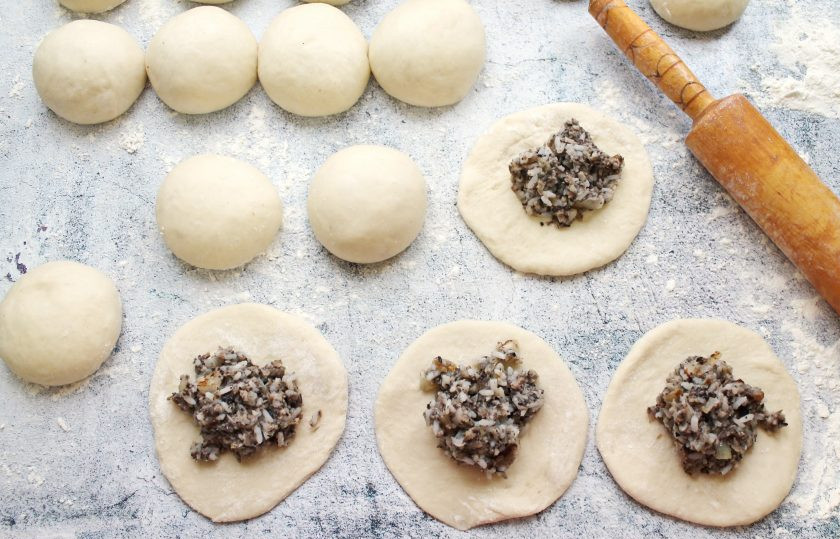 1. Этап. Пирожки с солеными груздями и рисом: Шарики теста раскатайте в лепешки и разложите начинку.