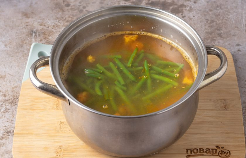 1. Этап. Суп с молодой фасолью: Молодую фасоль помойте, отрежьте хвостики и разрежьте на 2-3 части стручки. Добавьтев кастрюлю. Все перемешайте и варите до готовности картофеля. Посолите по вкусу.