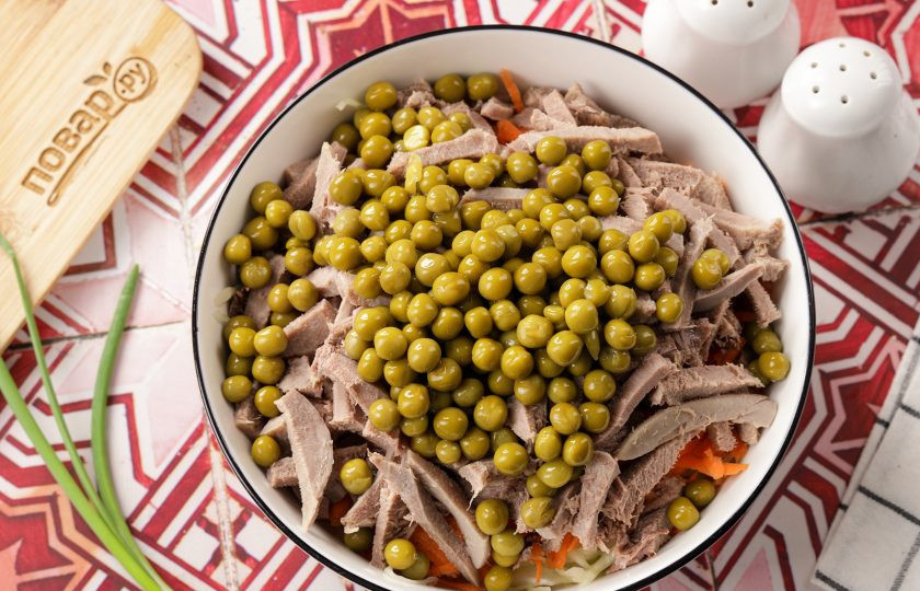 1. Этап. Салат с языком и капустой: Добавьте зелёный горошек без жидкости.