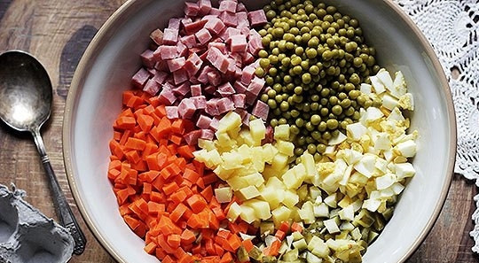 1. Этап. Салат Оливье классический: 2. Очистите морковь, картофель и яйца, нарежьте маленькими кубиками. Соленые огурцы и колбасу также нарежьте кубиками. Выложите все продукты в большую миску, добавьте консервированный горошек.