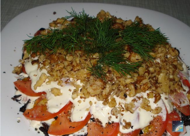 1. Этап. Салат Нежность с черносливом: Далее нарезаем ветчину, измельчаем орехи. Помидоры заправляем соусом, сверху кладем ветчину, потом орехи. Даем салату пропитаться несколько минут. Для красоты можно посыпать зеленью.