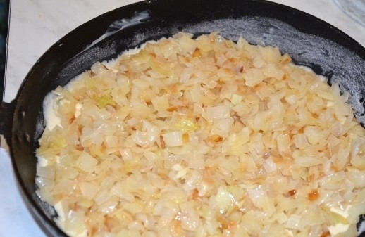 1. Этап. Заливной пирог с капустой: 6. Форму для запекания или сковороду смазываю сливочным маслом, вливаю немного больше половины теста и выкладываю приготовленную капустную начинку.