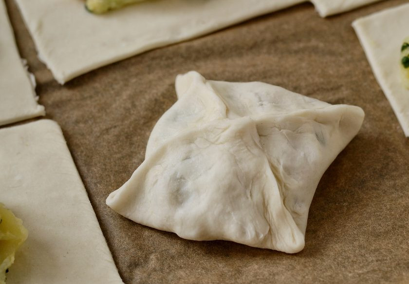 1. Этап. Слойки с картошкой: Соедините концы квадрата в центре, защипните края. Выпекайте слойки в духовке в течение 30 минут при температуре 185 градусов.