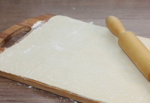 1. Этап. Мини-слойки с тунцом и оливками: 8. Раскатайте тесто до увеличения в 2,5 раза.